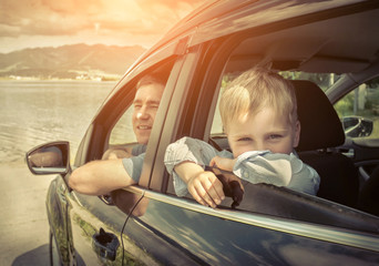 Father and son sitting in car
