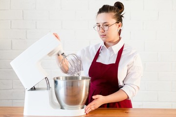 Cooking butter cream for the cake in white kitchen