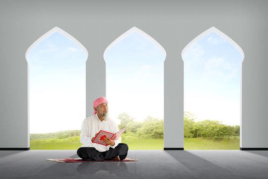 Senior asian muslim man sitting with Koran