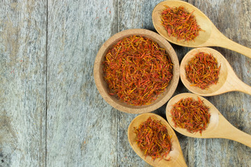 safflower in wood spoon on table