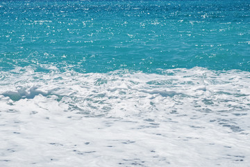Fototapeta na wymiar Waves with white foam at beautiful sea