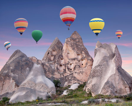 Colorful hot air balloons flying over formations of Red valley in Cappadocia, Anatolia, Turkey