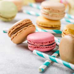 French assorted macarons on light gray concrete background. Holidays food concept. Copy space.