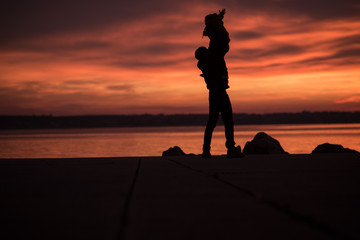 Young father lifting a small child into the air