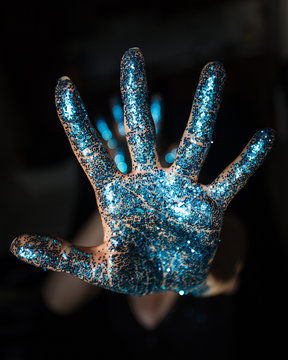 palmo della mano con brillantini azzurri