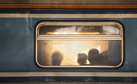 Fototapeta Silhouettes of passengers in old train wagon
