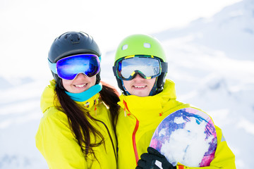 Photo of sports woman and man with snowboard against background of mountains