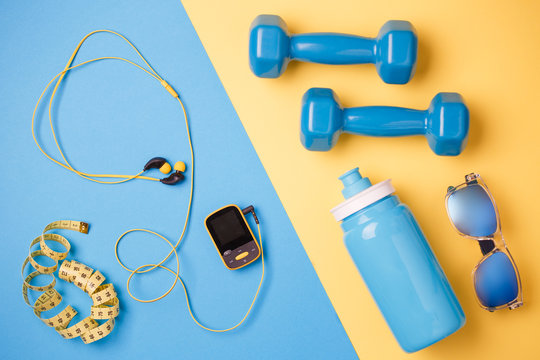 Photo of player, dumbbells, bottle of water, centimeter tape on blue and yellow background