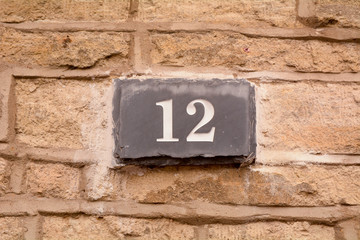 House number 12 sign on slate fixed to wall