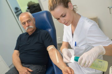 doctor testing blood to a senior patient