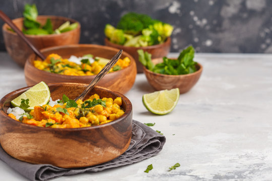 Vegan Sweet Potato Chickpea curry in wooden bowl on light background. Healthy vegetarian food concept.