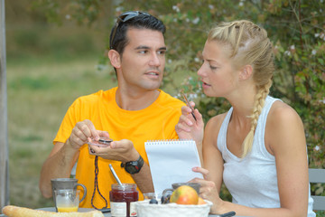 couple making notes while having breakfast