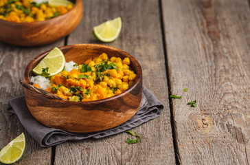 Vegan Sweet Potato Chickpea curry in wooden bowl on a wooden background. Healthy vegetarian food concept.