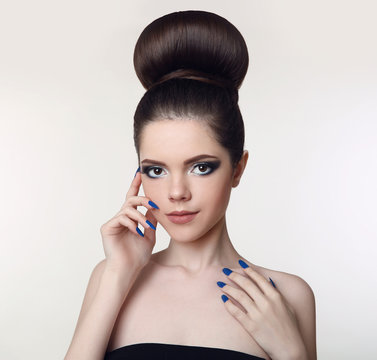 Beauty makeup girl. Bun Hairstyle.  Matte lipstick. Manicure nail. Young fresh brunette with glitter eyeshadow isolated on studio background.