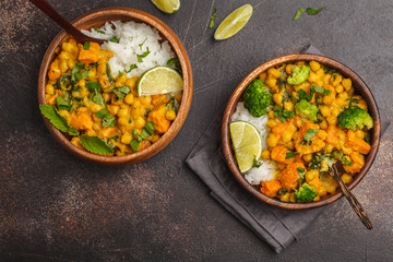 Vegan Sweet Potato Chickpea curry in wooden bowl on a dark background, top view. Healthy vegetarian food concept. - obrazy, fototapety, plakaty
