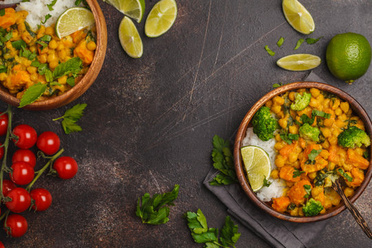 Vegan Sweet Potato Chickpea curry in wooden bowl on a dark background, top view, copy space. Healthy vegan food concept.