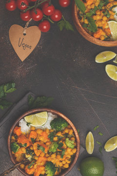 Vegan Sweet Potato Chickpea curry in wooden bowl on a dark background, top view, copy space. Healthy vegan food concept.