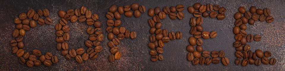Word coffee made from coffee beans, dark rusty background, top view