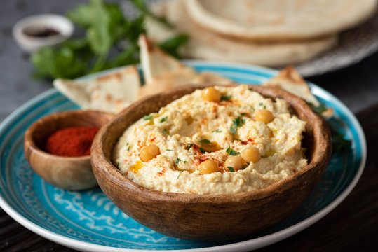 Traditional chickpea hummus in bowl, pita and paprika. Healthy vegan spread, arabic food. Selective focus.