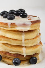 Pancakes with blueberry and condensed milk on white background