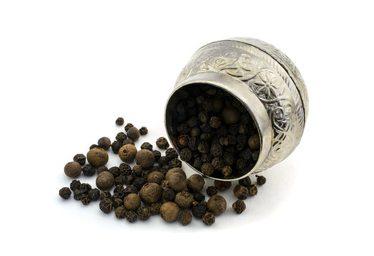 Spices black peas pepper sprinkled next to vintage metal dishes