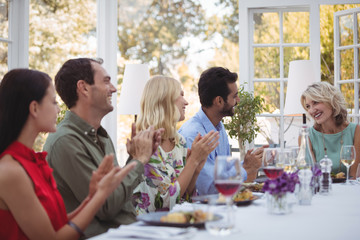 Group of friends interacting with each other while having meal together