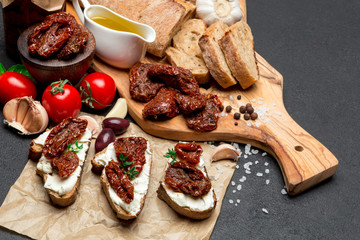 bruschetta with Canned Sundried or dried tomato halves on craft pepper - obrazy, fototapety, plakaty