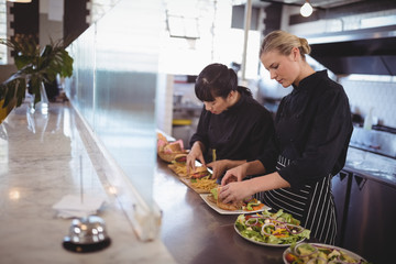 Young female chefs preparing fresh food at cafeteria