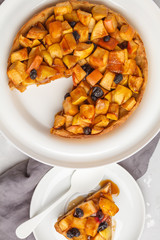 Vegan apple pie with cinnamon, raisins and caramel, gray background, top view