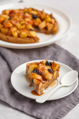 Vegan apple pie with cinnamon, raisins and caramel, gray background, vertical