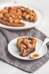 Vegan apple pie with cinnamon, raisins and caramel, gray background, vertical