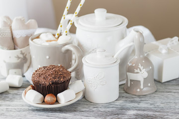 Cups with cacao and marshmallow, cupcakes and different decorations