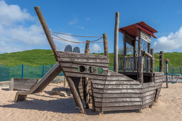 pirate boat slide and climbing frame in a playground