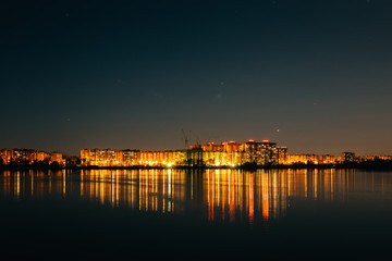 Fototapeta na wymiar Panorama of city buildings lights reflection in water at night sky background, minimalism urban style