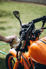 Adult and experienced biker cleaning and washing his motorcycle