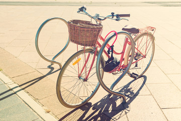 Fototapeta na wymiar Pink vintage bicycle with basket on steering wheel