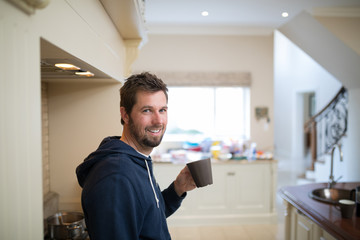 Naklejka na ściany i meble Man holding a cup of coffee at home