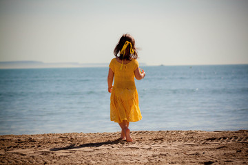 Happy little girl running on the beach