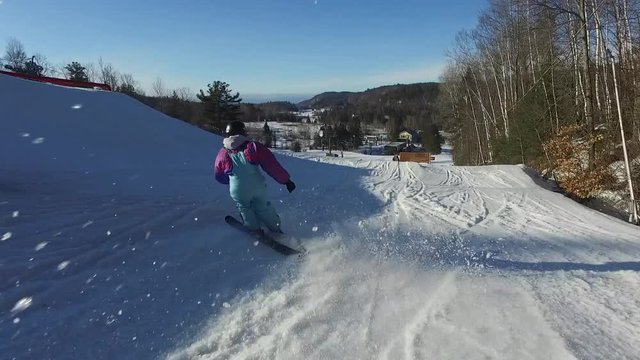 Female skiier carving down ski hill