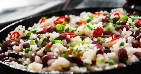 rice with red beans and vegetables in a frying pan