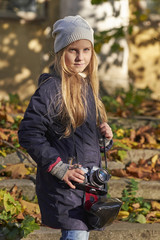 Fototapeta na wymiar small photographer in an autumn park