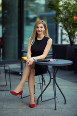 Beautiful girl sitting on the table and do her work, talk at phone, write mail