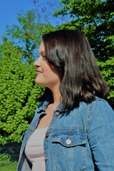 profile of a young satisfied woman in the park
