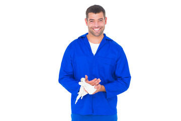 Smiling mechanic wiping hands with cloth