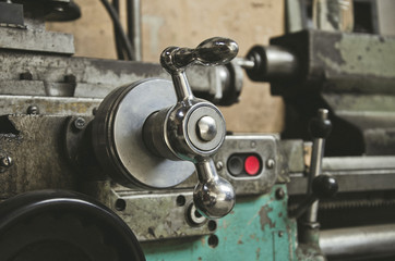 Adjustment knob on a vintage lathe in the workshop of a locksmith