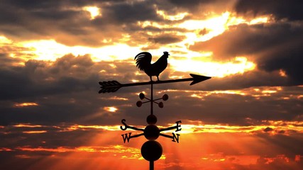 Weathervane cockerel floating against red sunset