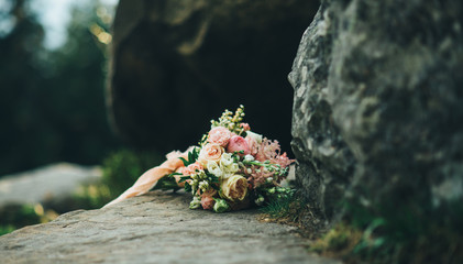 beautiful wedding bouquet is lying on the stone