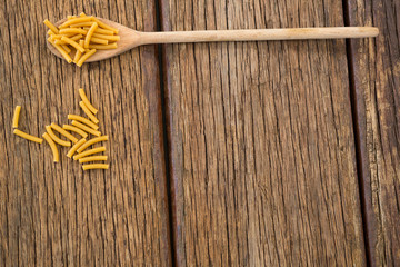 Macaroni pasta on wooden surface