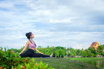 Young Asian woman practicing yoga in the park