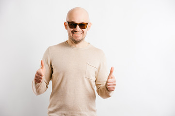 Naklejka premium Adult bald happy businessman in sunglasses showing thumbs up. Cheerful smiling man face expression. Agree hands gestures. Successful guy portrait. Everything`s fine. No problem. Excited male person